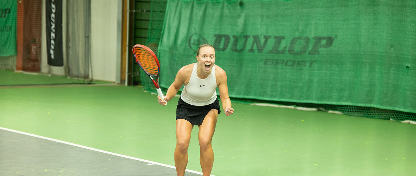 Jubelnde Siegerin auf dem Tennisplatz
