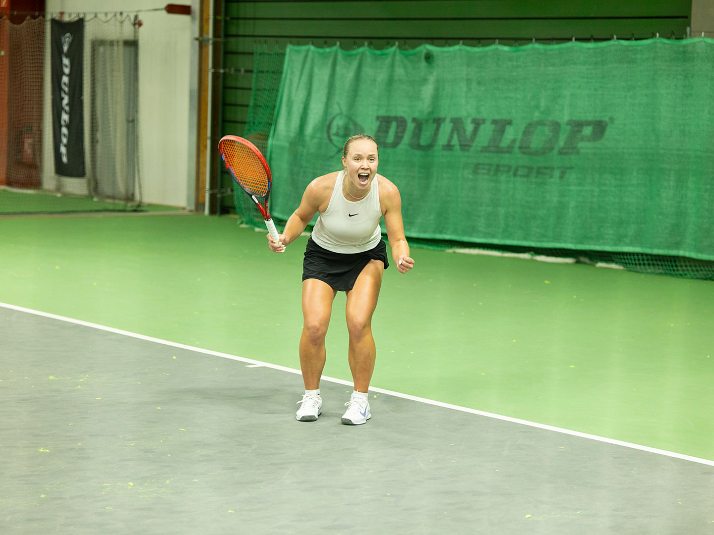 Jubelnde Siegerin auf dem Tennisplatz