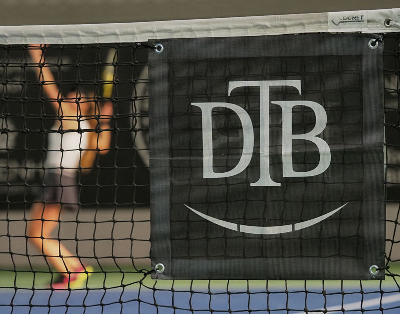 DTB-Branding im Tennisnetz bei den Deutschen Meisterschaften 2021. Im Hintergrund schlägt Alexandra Vecic auf. Fotograf Jürgen Pichler