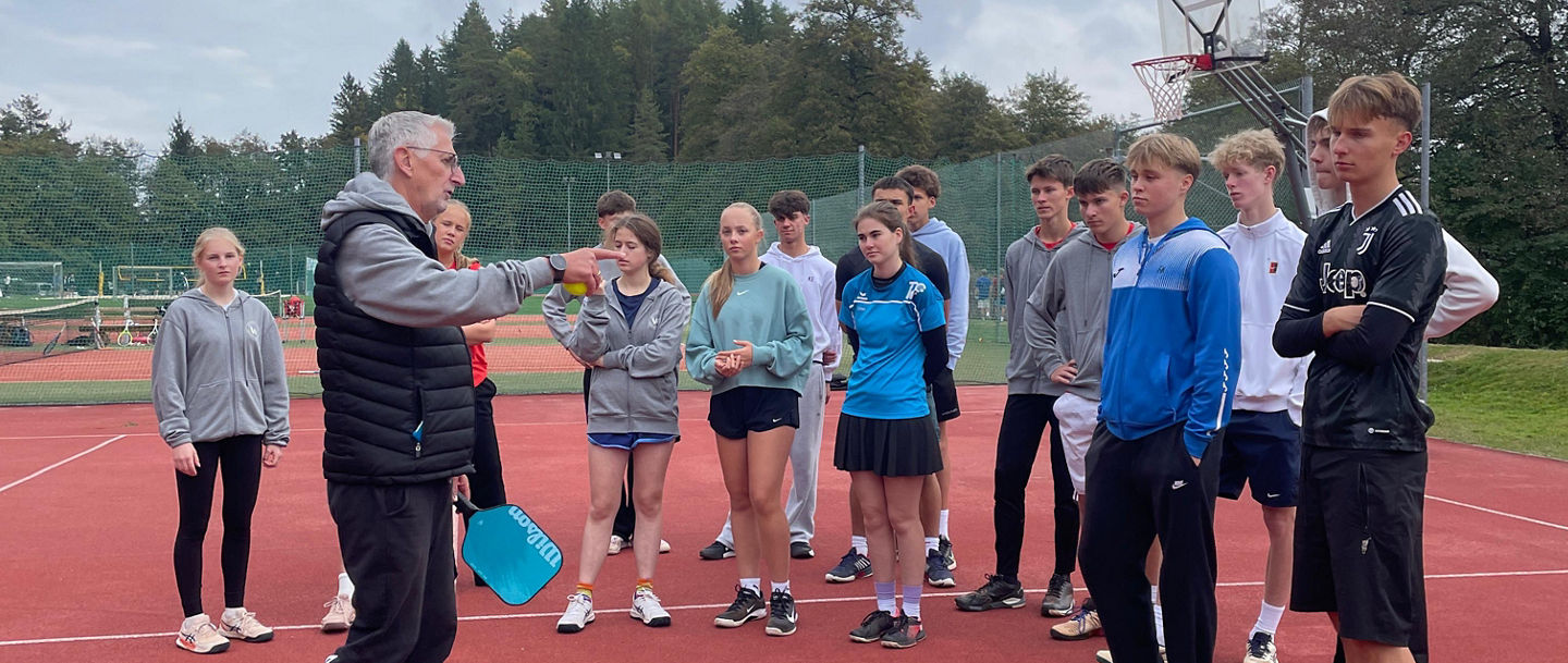 Die Jugendlichen bereiten sich auf die Tenniseinheit vor.