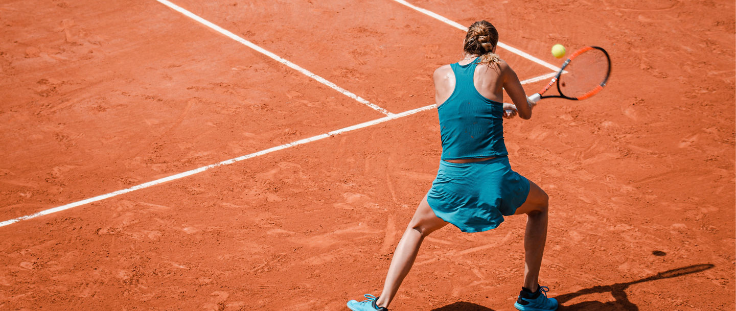 Back view  of a woman playing backhand in tennis outdoor competition game, running, professional