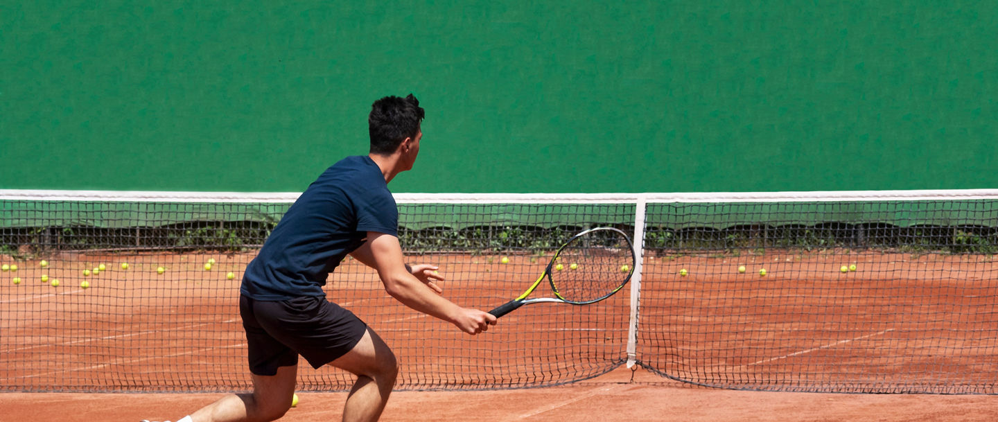 Tennissspieler auf dem Platz hält einen Schläger