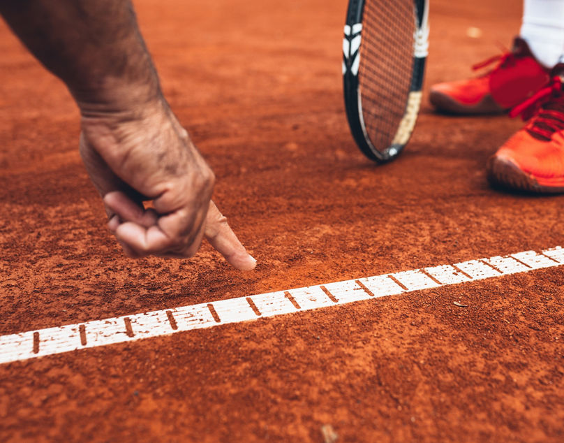 close up of referee showing that the ball was out on tennis court