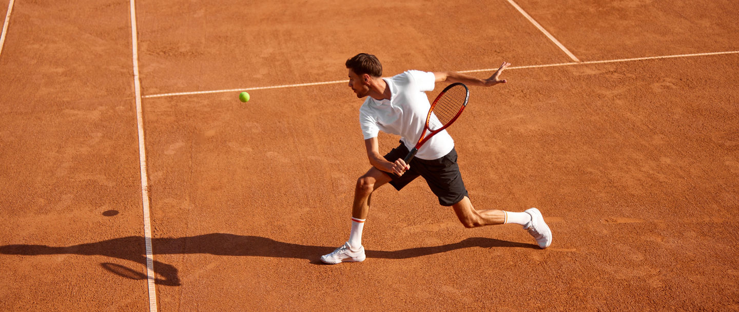 Ein Tennisspieler auf dem Platz ist kurz davor den Ball zu spielen 