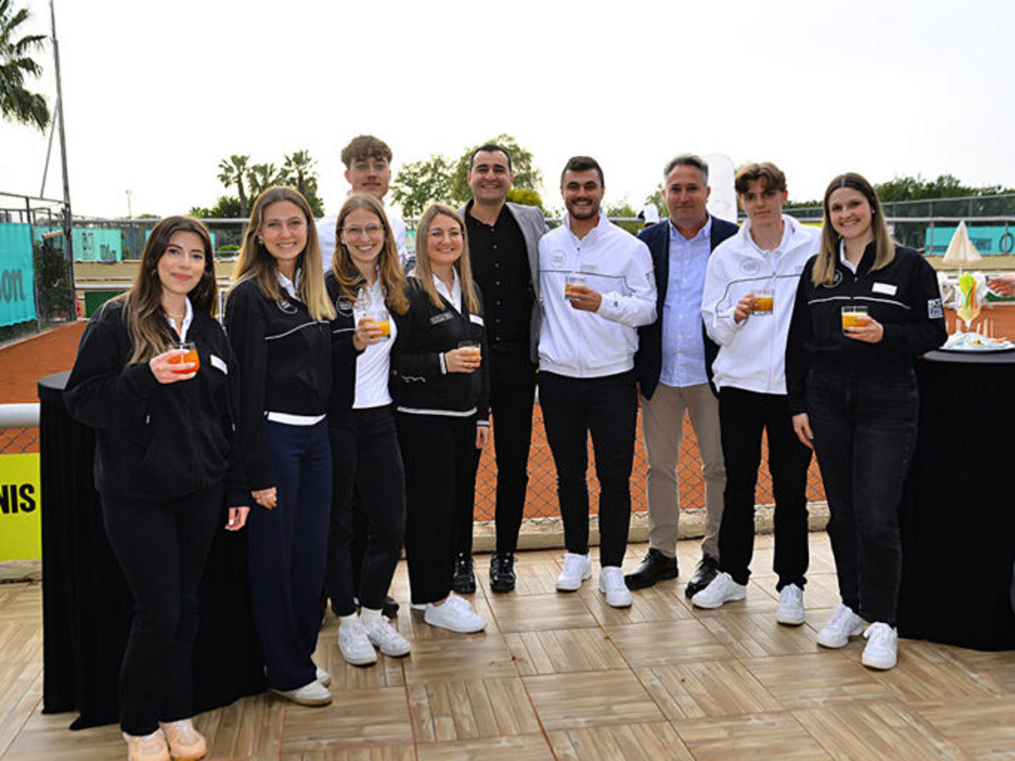 Gruppenfoto von Patricio Travel vor einem Tennisplatz