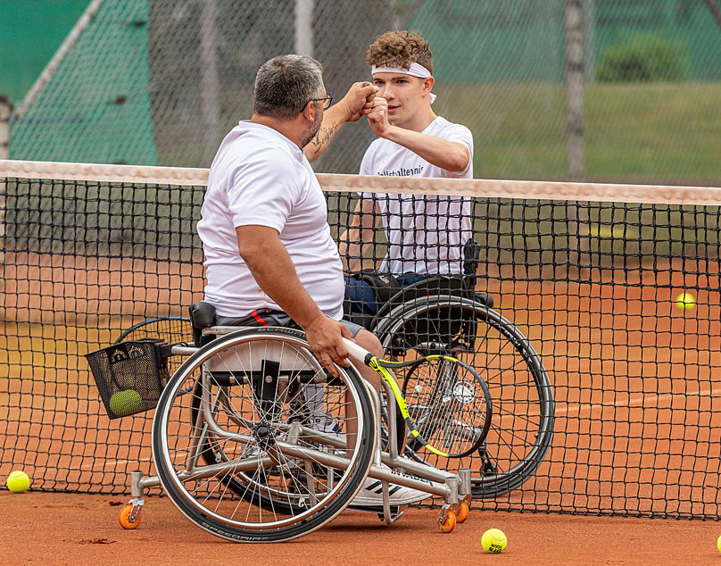 Rollstuhl-Tennisspieler klatschen sich ab