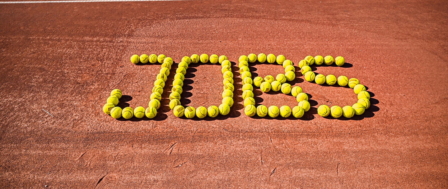 "Jobs"-Schriftzug auf Tennisplatz