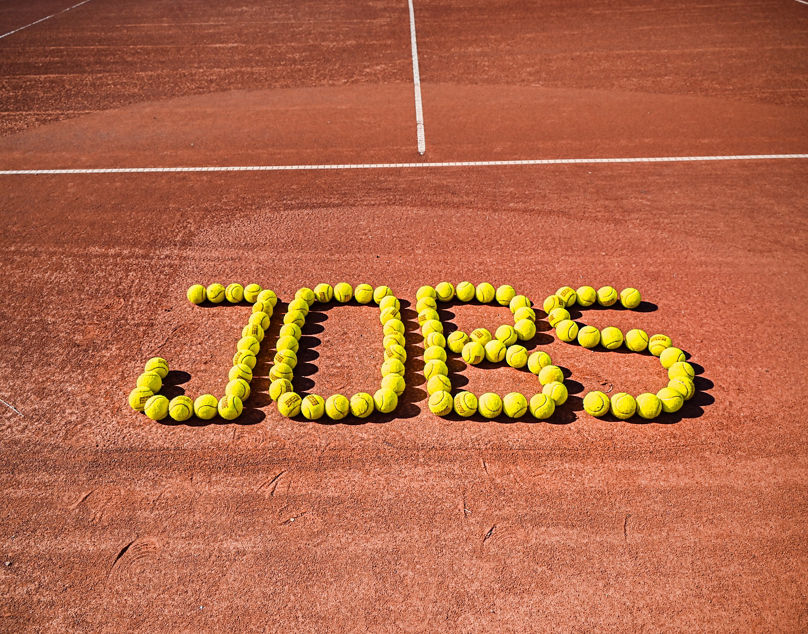 "Jobs"-Schriftzug auf Tennisplatz