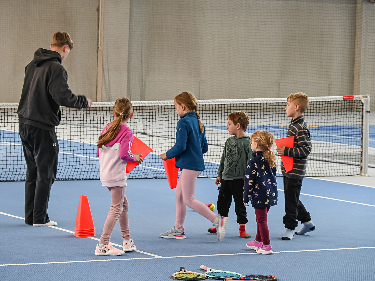 Fünf Kinder beim Aufbau einer Übung mit einem Trainer