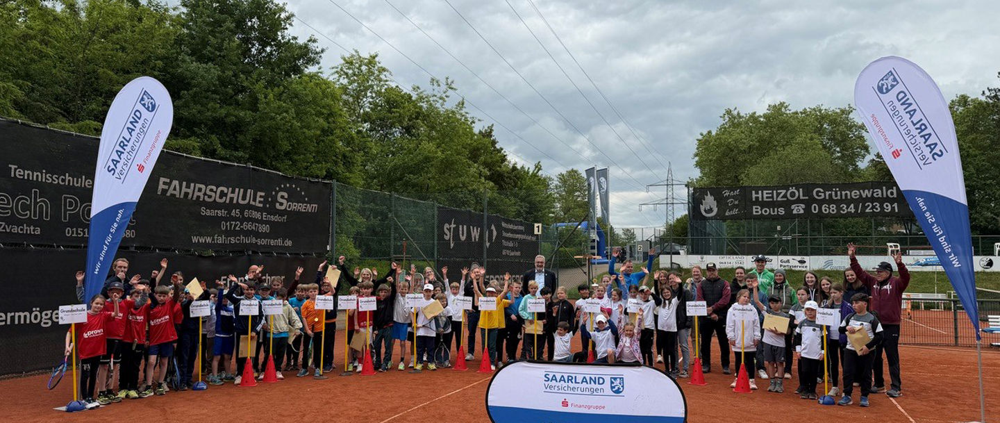 Schüler:innen bei den Grundschul-Saarlandmeisterschaften in Teams auf dem Tennisplatz aufgestellt