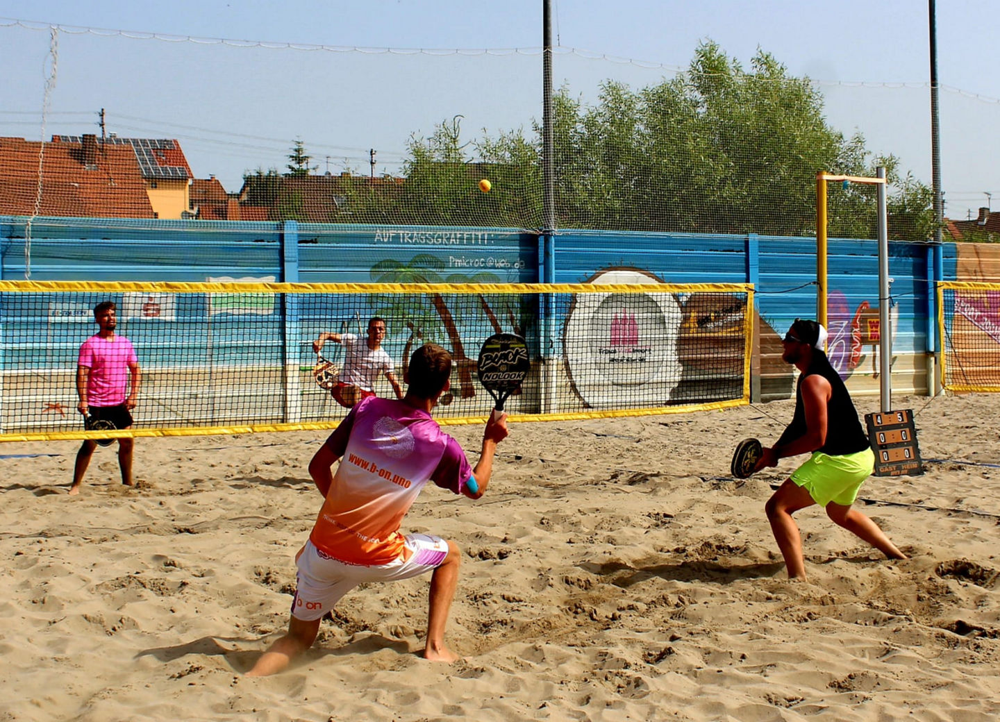 Zwei Padel-Spieler:innen jubeln auf dem Court mit den Zuschauern im Hintergrund