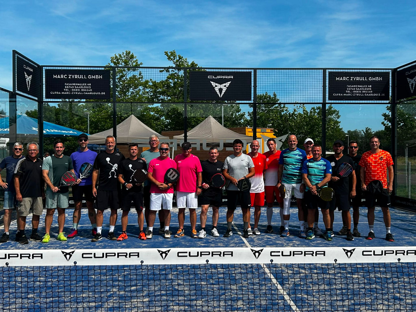Gruppenfoto aller Teilnehmenden der Herren 40 auf dem Padelplatz hinter dem Netz