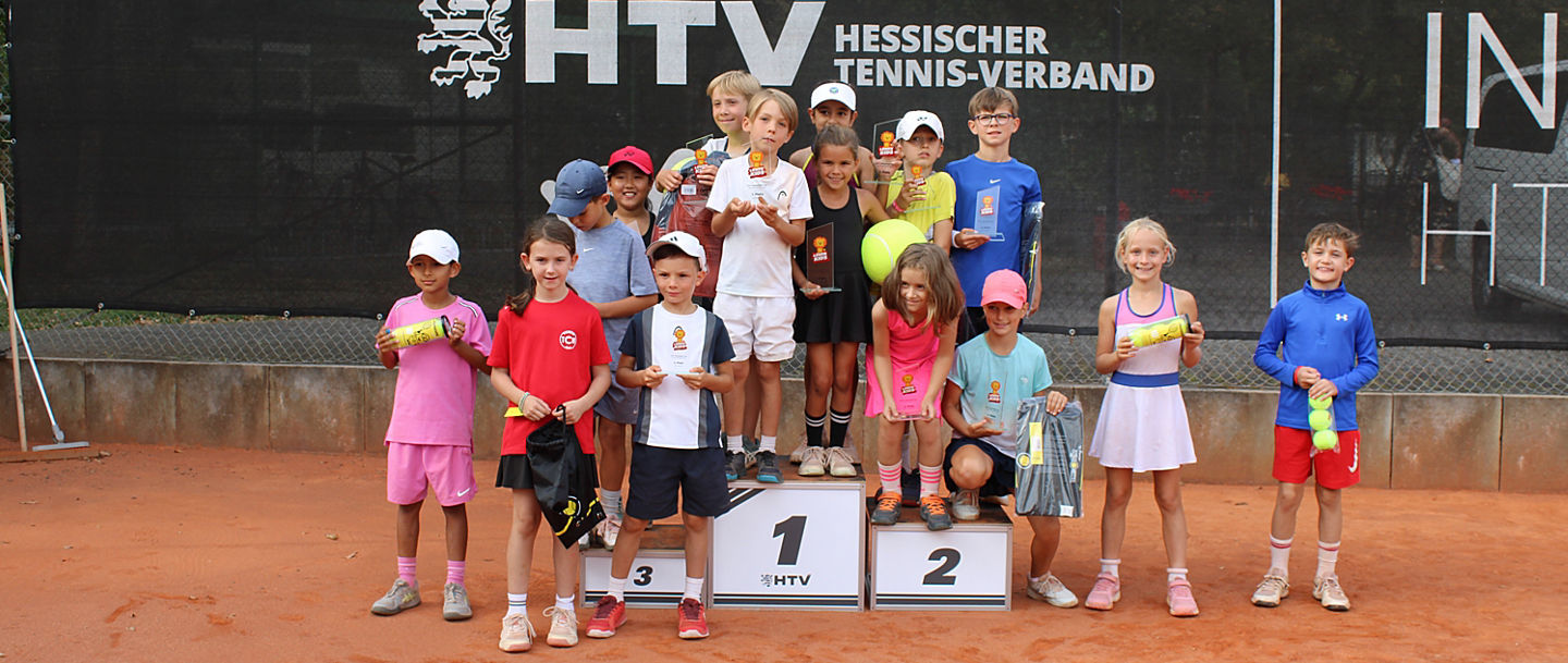 Große Siegerehrung beim Sommerfinale der HTV-Löwenkids-Tour 2026 im HTV-Landesleistungszentrum Offenbach: Die erfolgreichen Spielerinnen und Spieler der U8- und U9-Konkurrenzen präsentieren sich mit ihren Pokalen und Sachgeschenken rund um das Siegertreppchen.
