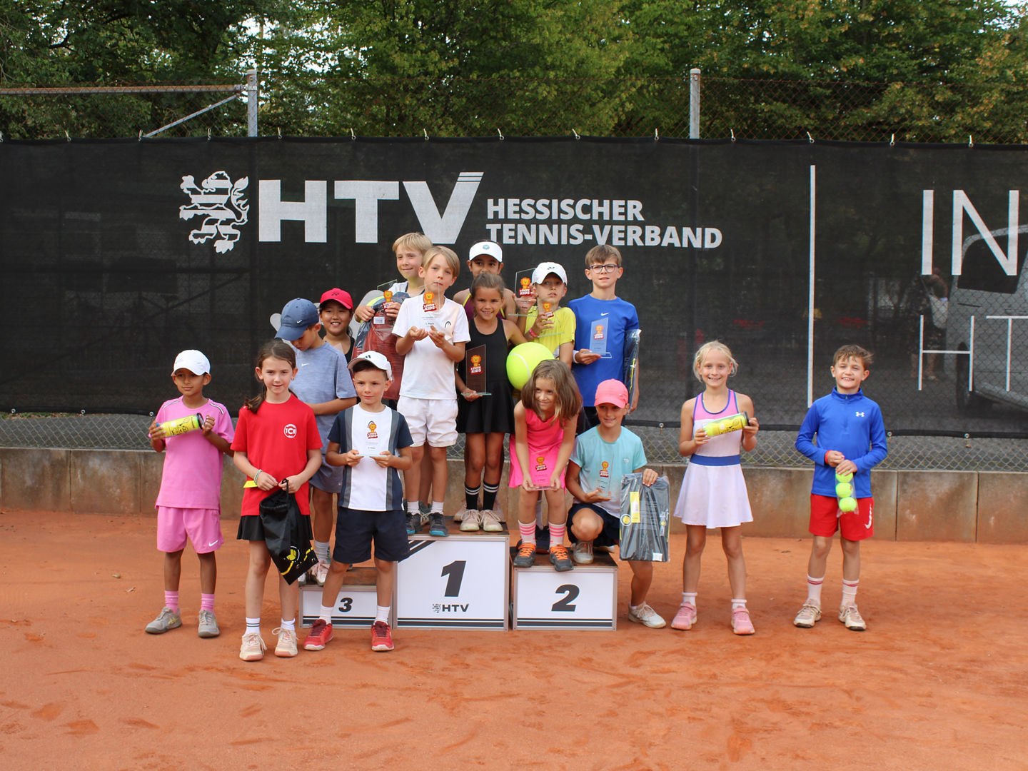 Große Siegerehrung beim Sommerfinale der HTV-Löwenkids-Tour 2026 im HTV-Landesleistungszentrum Offenbach: Die erfolgreichen Spielerinnen und Spieler der U8- und U9-Konkurrenzen präsentieren sich mit ihren Pokalen und Sachgeschenken rund um das Siegertreppchen.