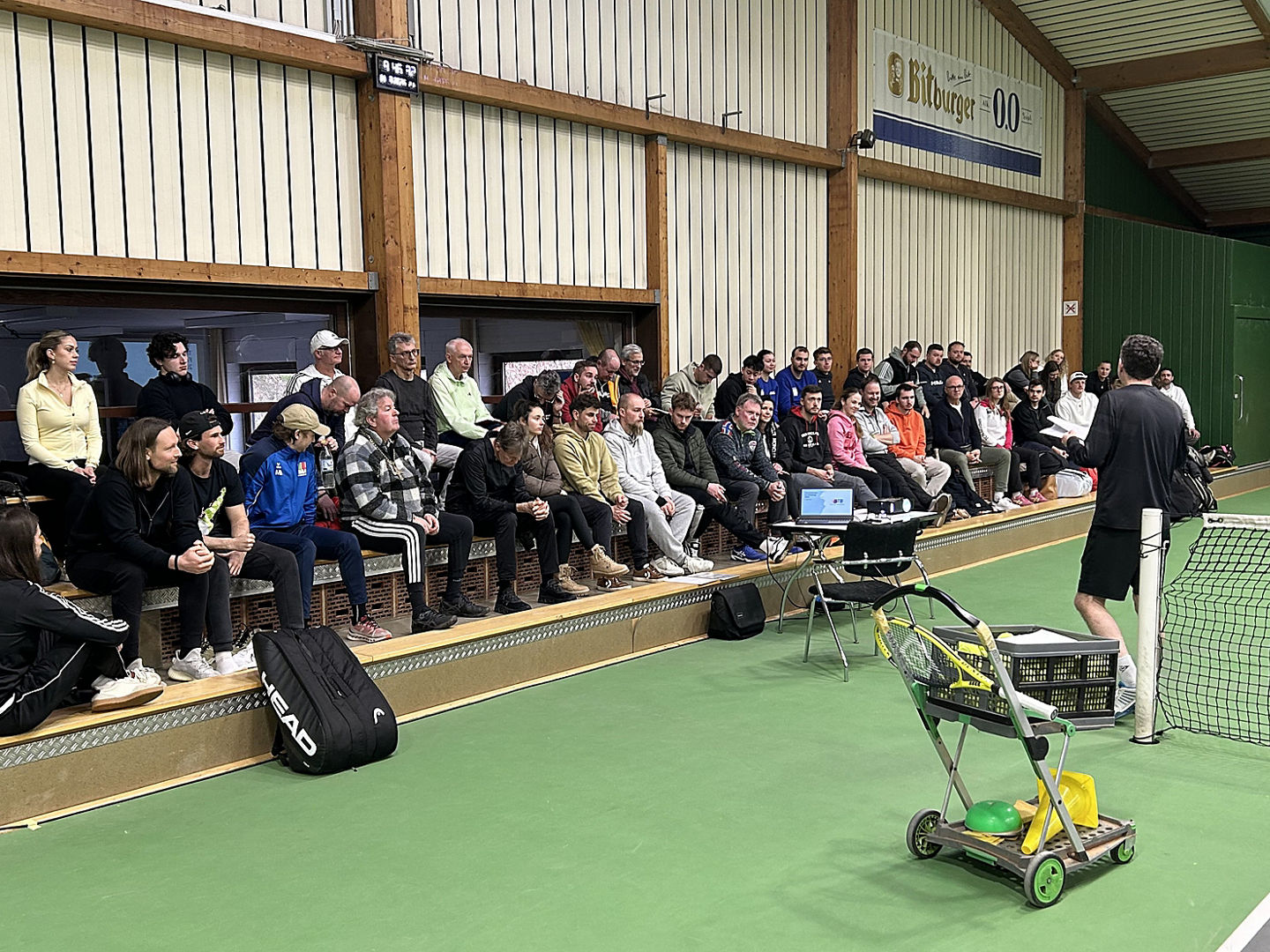 Teilnehmende der STB-Trainerfortbildung 2026 in der Tennishalle auf der Tribüne in der Tennishalle sitzend