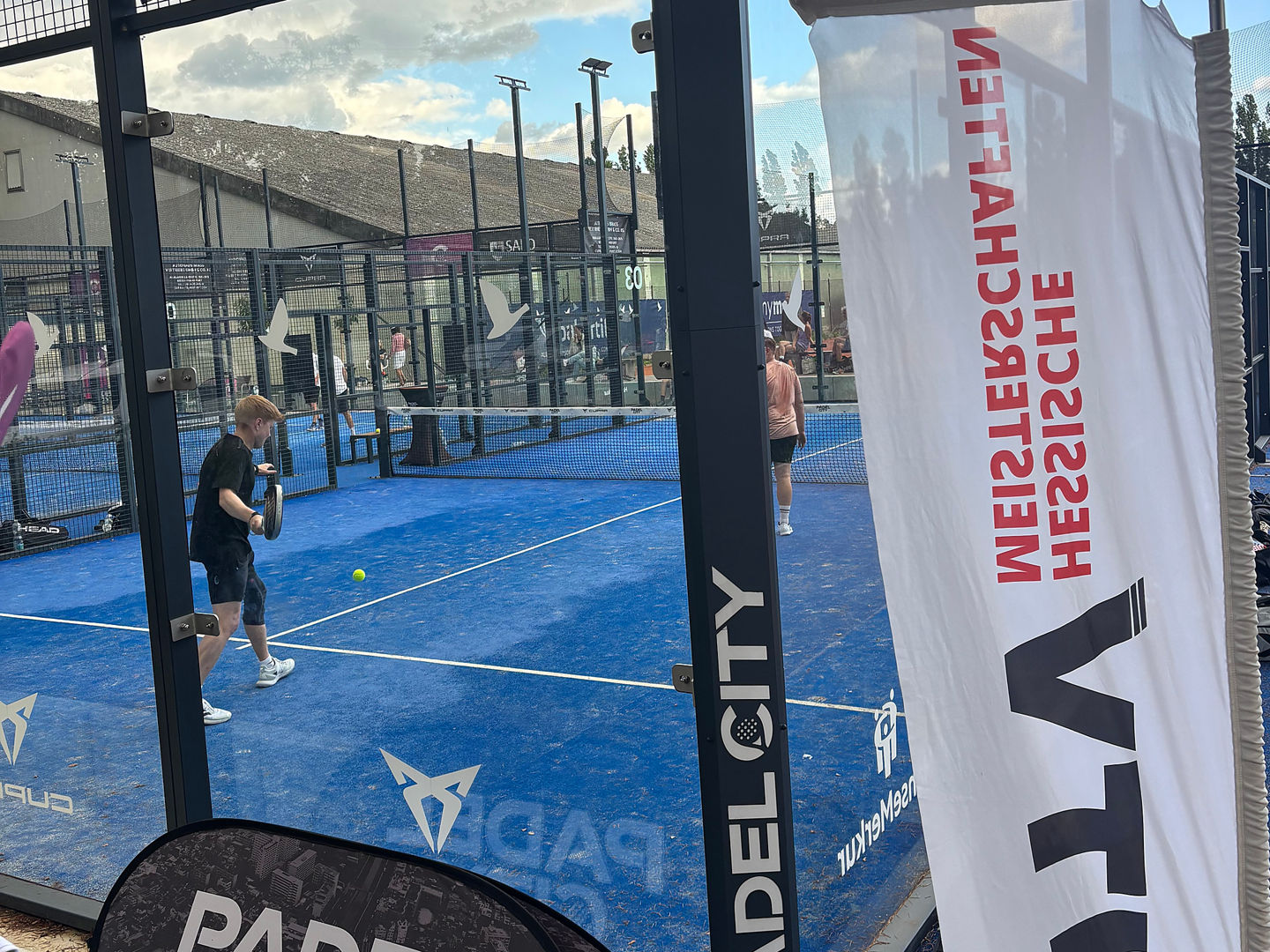 Padel court with players and banners