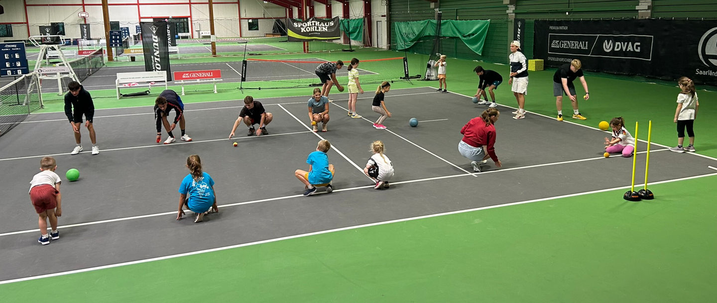 Angehende Trainer:innen in der Tennishalle bei Übungen mit den Kindern