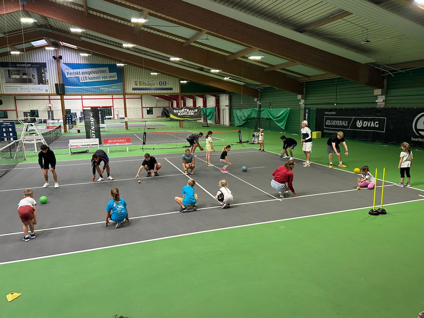 Angehende Trainer:innen in der Tennishalle bei Übungen mit den Kindern