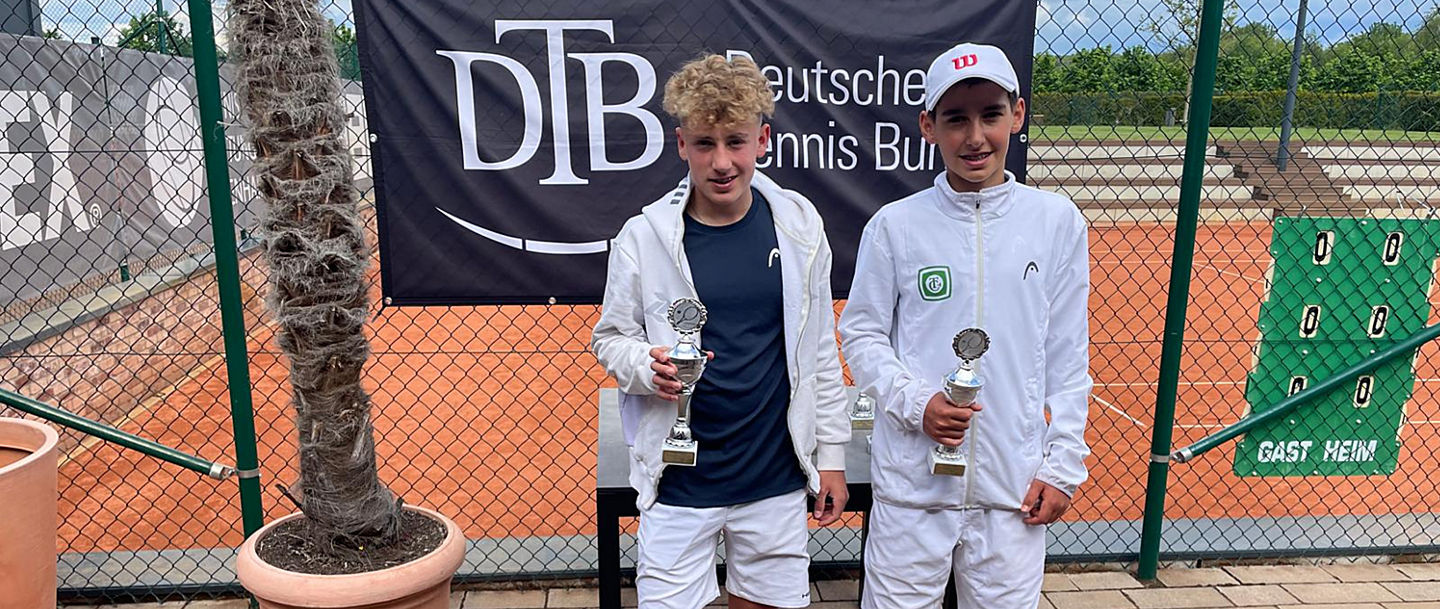 Jaro Schindler mit Partner David Schwenk mit den Pokalen vor dem DTB-Banner