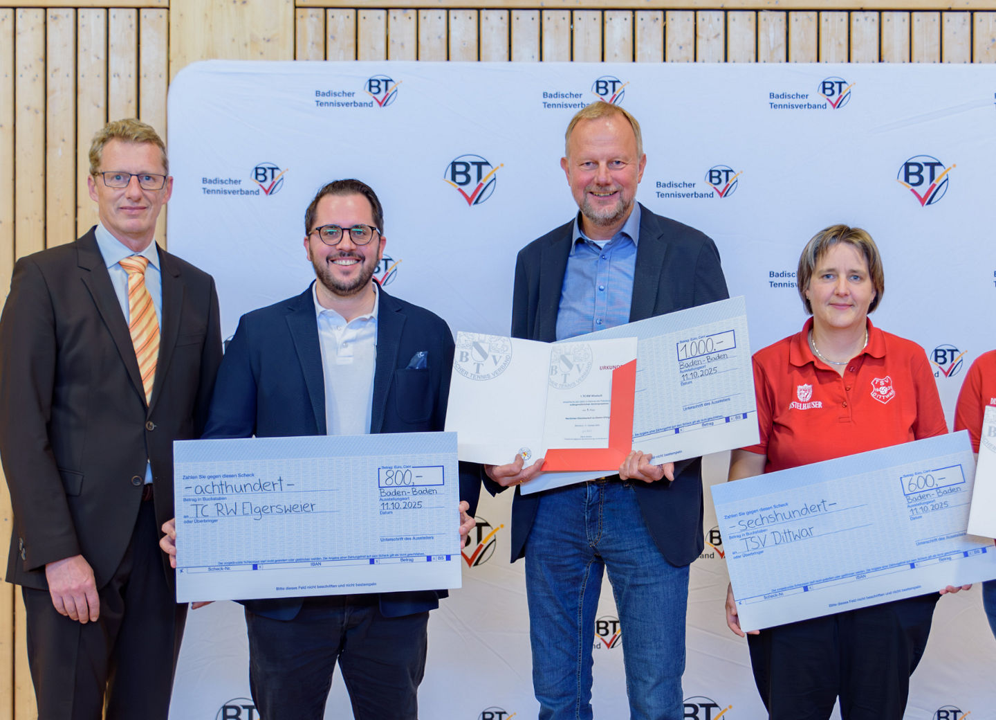 Vereinsvertreter:innen erhalten Schecks und Urkunde überreicht