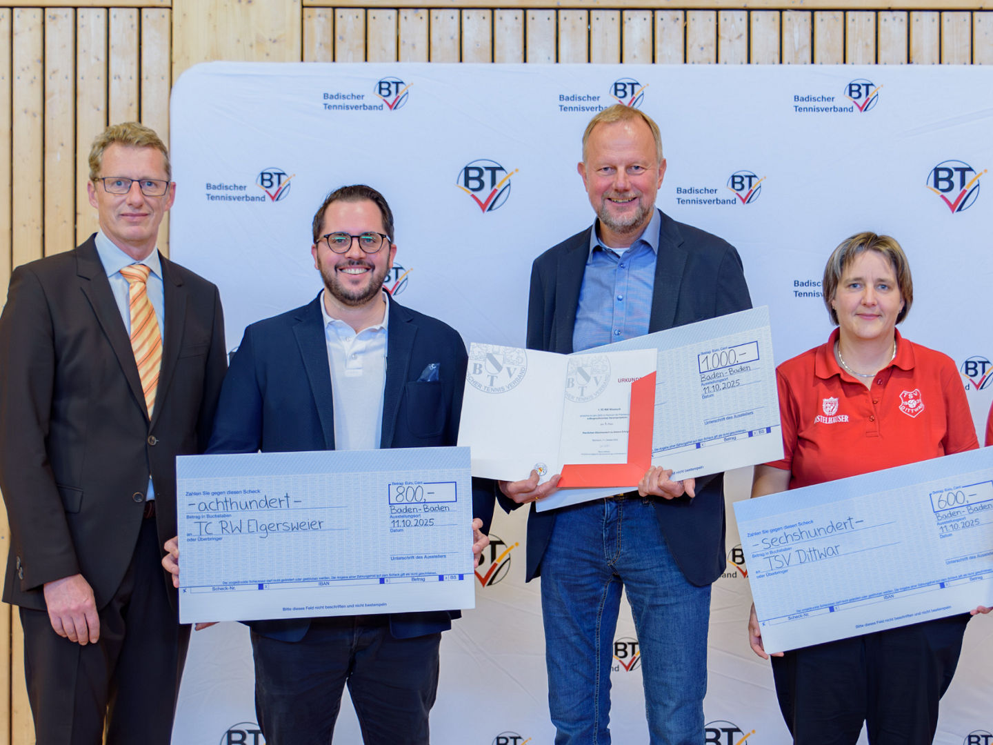 Vereinsvertreter:innen erhalten Schecks und Urkunde überreicht