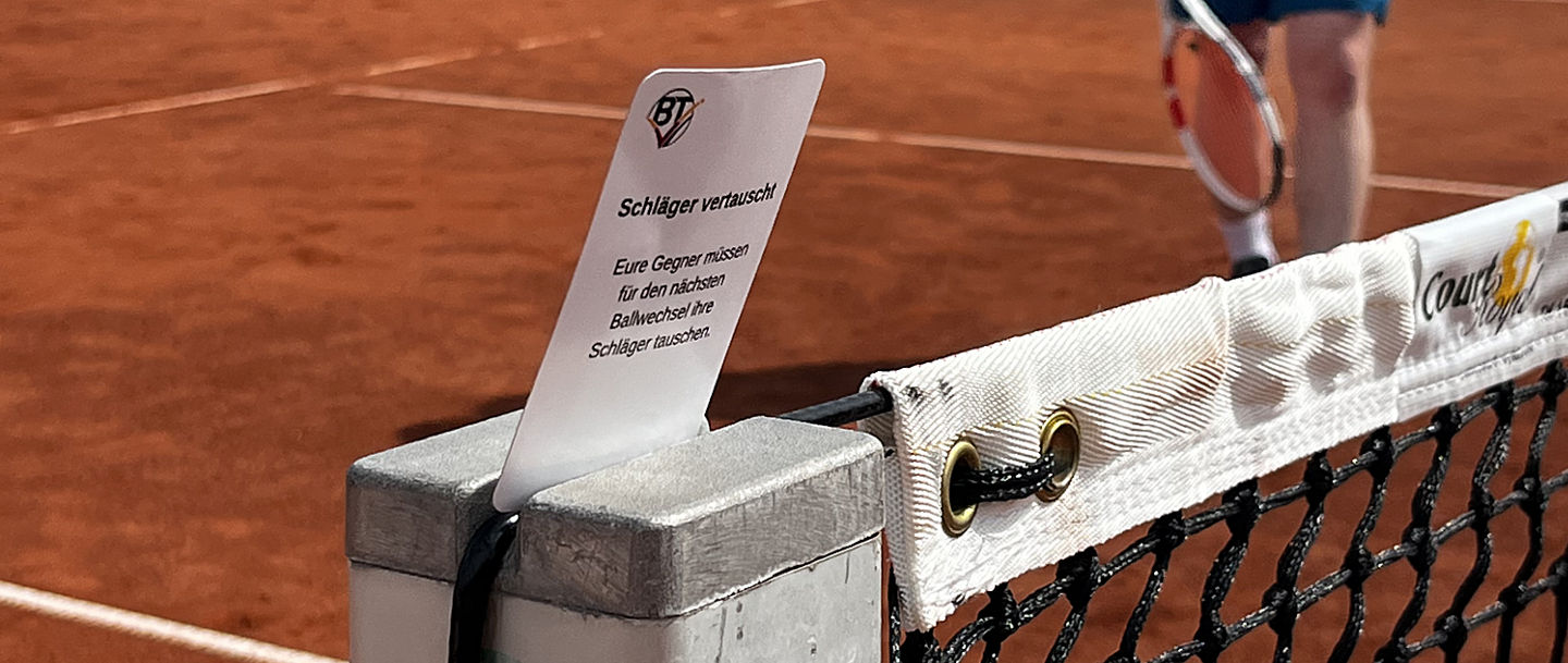 Eine Jokerkarte vor dem Netz auf dem Tennisplatz