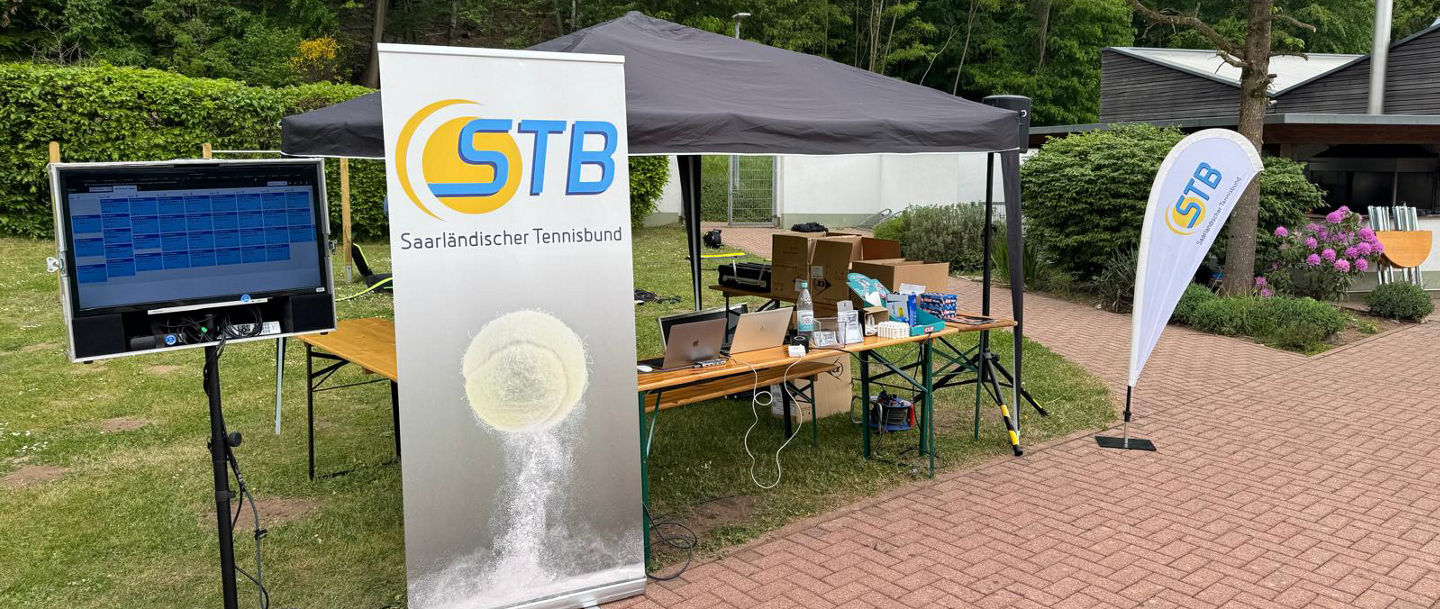 Zelt auf der Tennisanlage, unter dem ein Tisch und Equipment der Turnierleitung steht