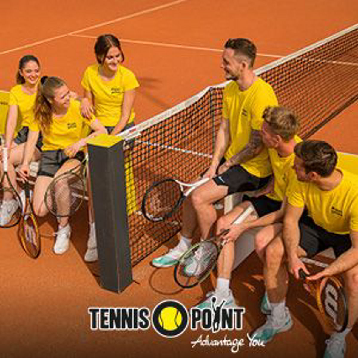 Personen sitzen gemeinsam am Tennisplatz