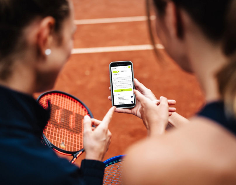 Frauen zeigen auf ein Handy, das die DTB-Rangliste zeigt