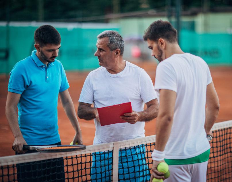 Tennisspieler rutscht auf Sandplatz