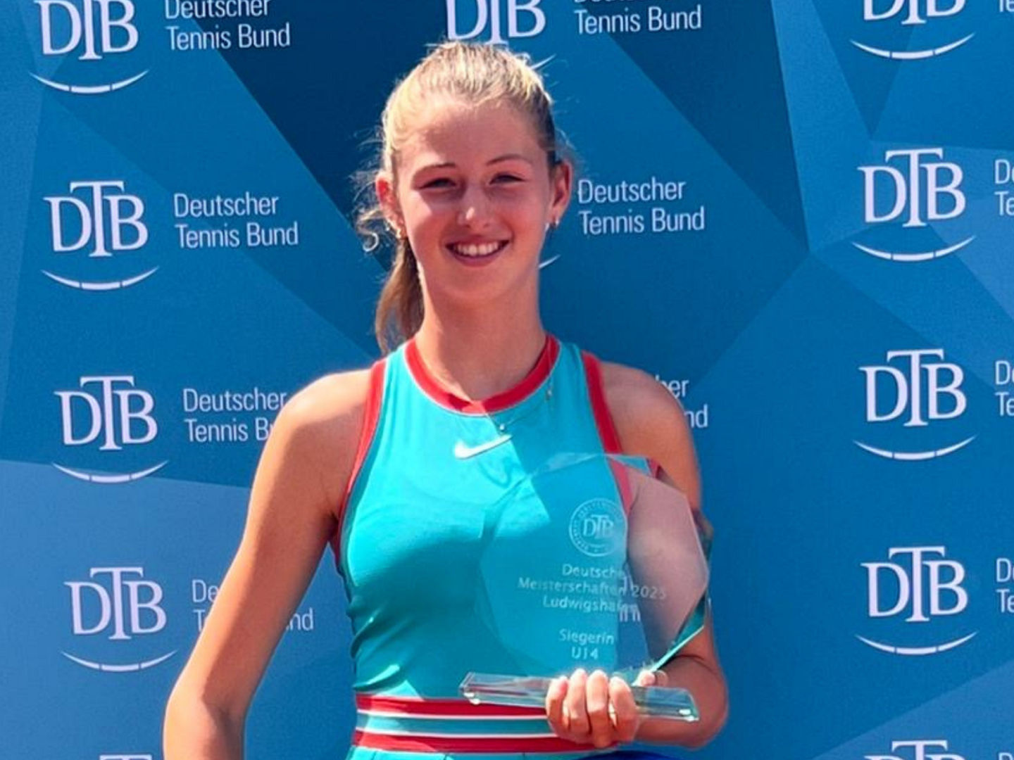 Lilly Marie Greinert mit Trophäe vor der Pressewand des DTB