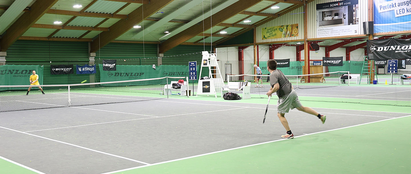 Match zwischen zwei Tennisspieler in der Tennishalle mit grauem Feld und grünem Boden