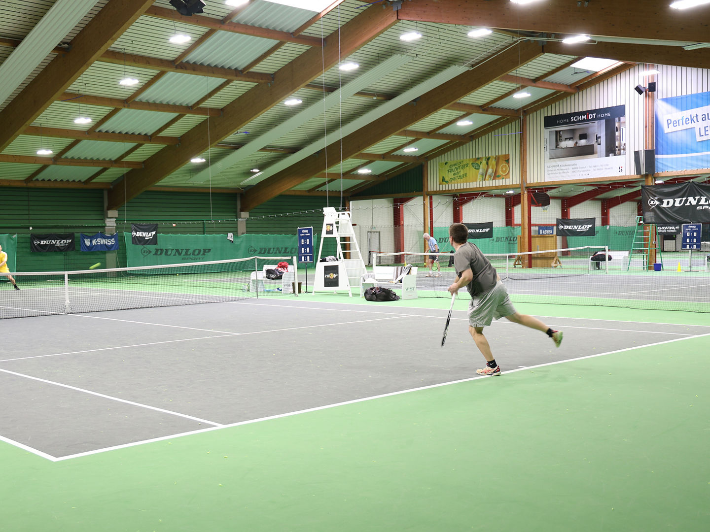 Match zwischen zwei Tennisspieler in der Tennishalle mit grauem Feld und grünem Boden