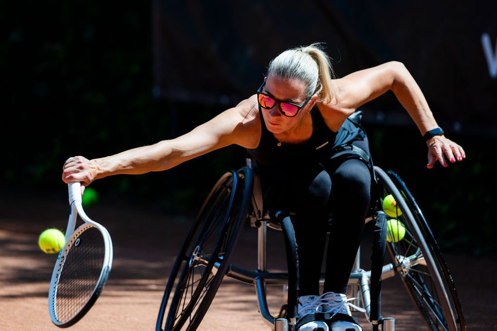 A wheelchair tennis player competing on a court.