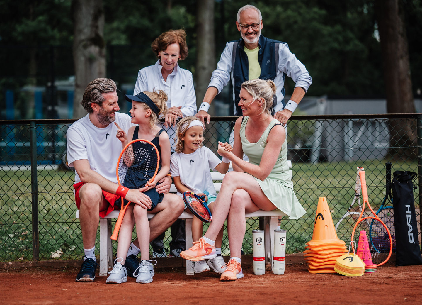 Tennisfamilie auf der Bank