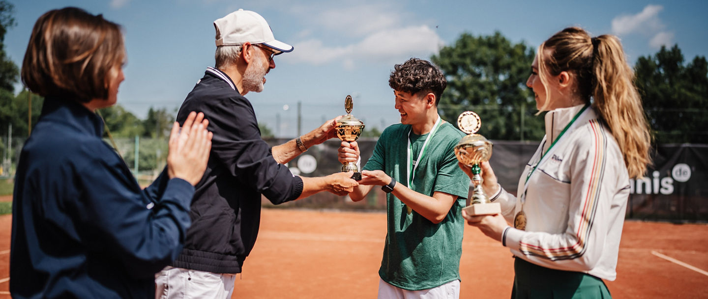 Zwei Spieler:innen bekommen einen Pokal