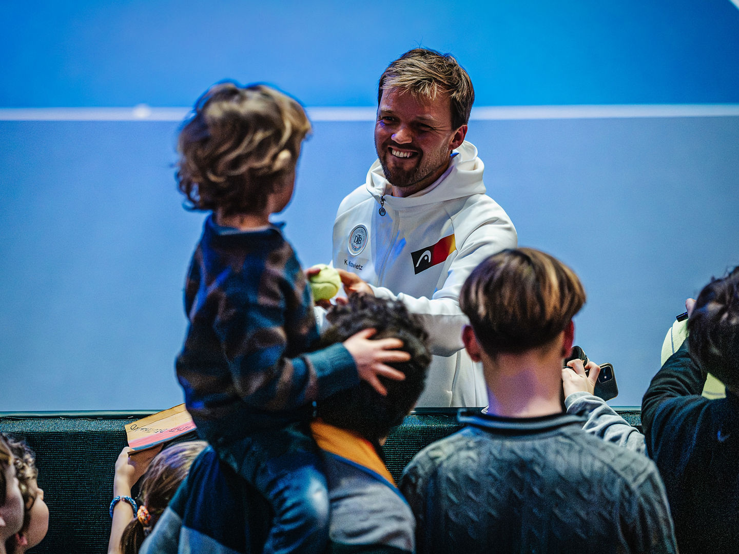 Kevin Krawietz schenkt kleinem Jungen beim Davis Cup in Düsseldorf einen Ball.