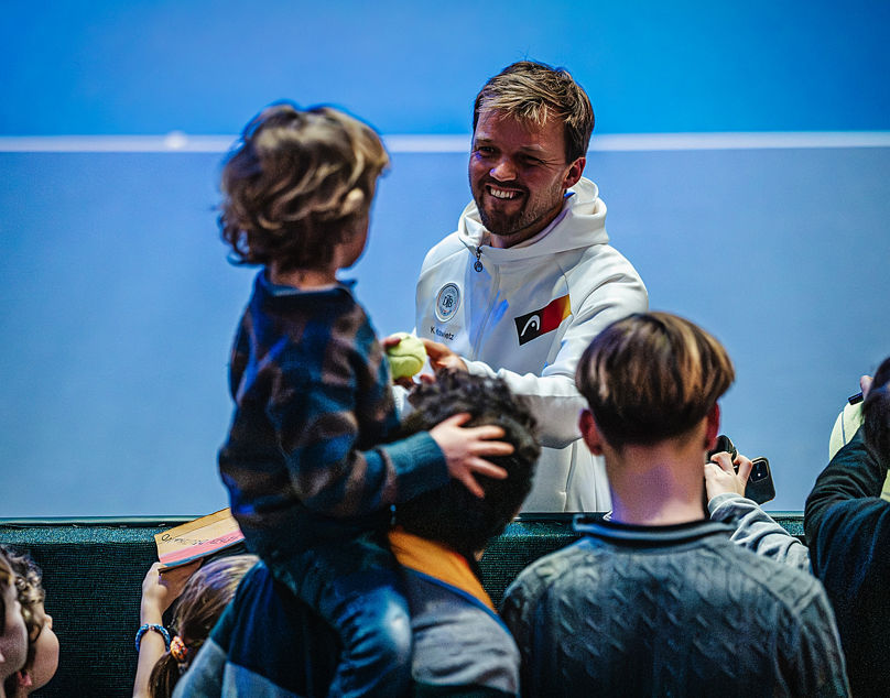 Kevin Krawietz schenkt kleinem Jungen beim Davis Cup in Düsseldorf einen Ball.