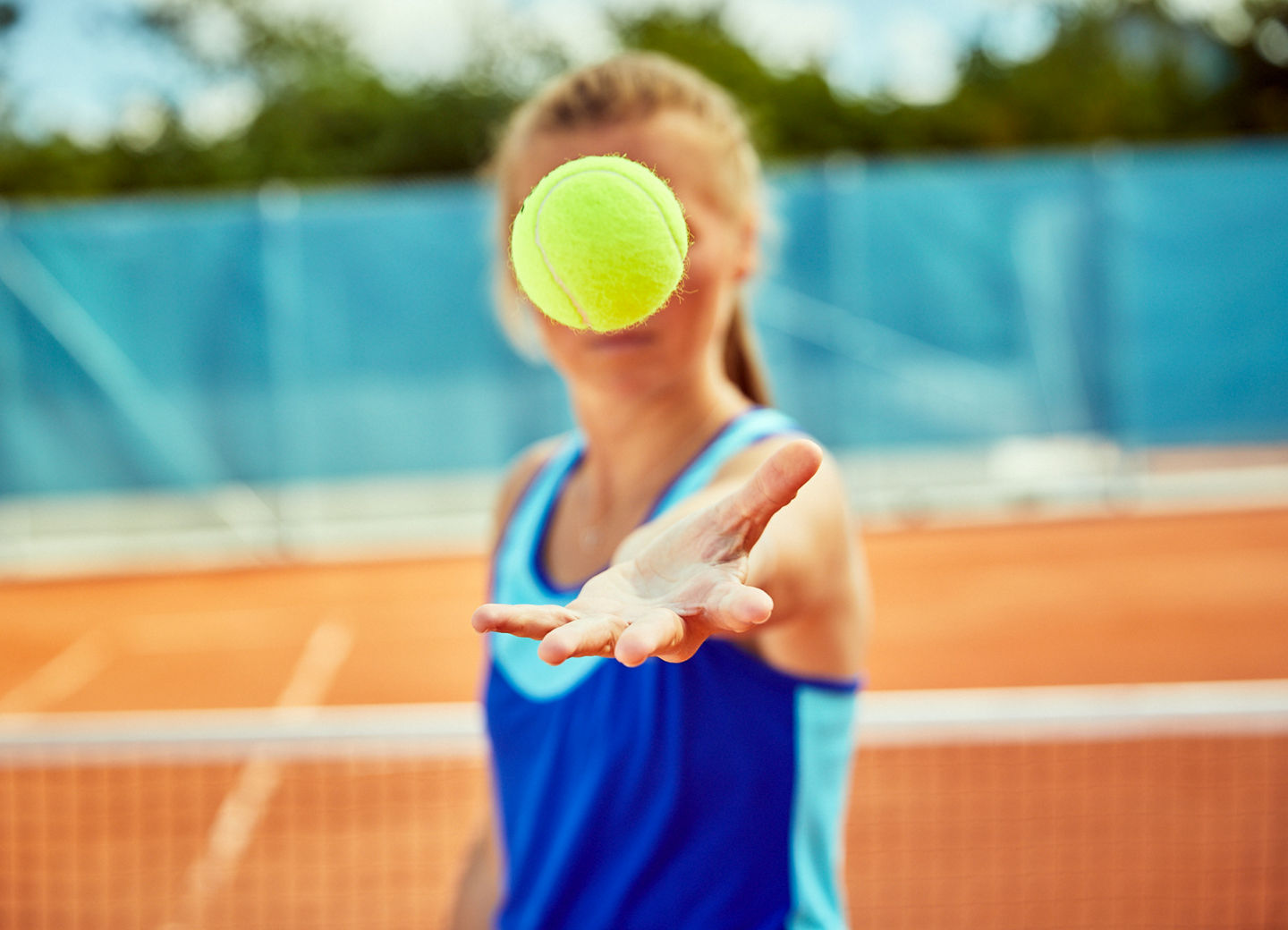 Spielerin wirft einen Tennisball hoch