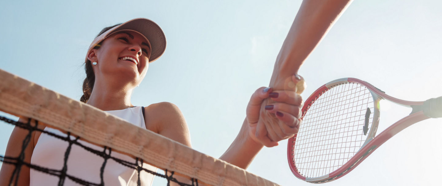 Tennis players shaking hands at net