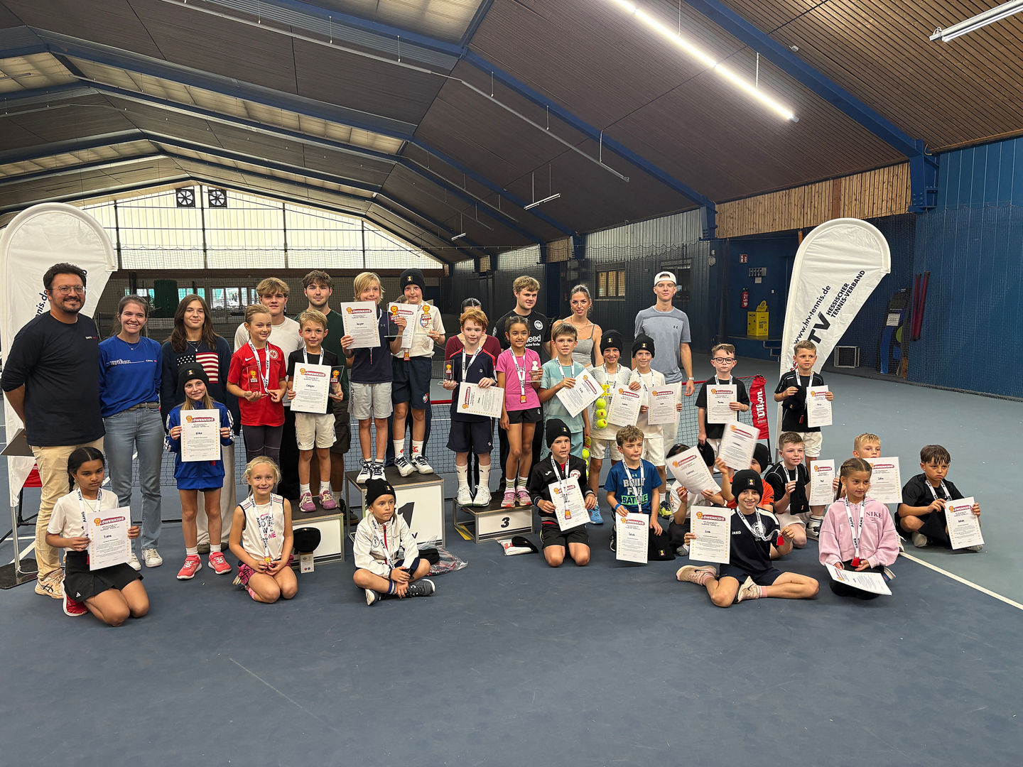 Group of young tennis players with awards