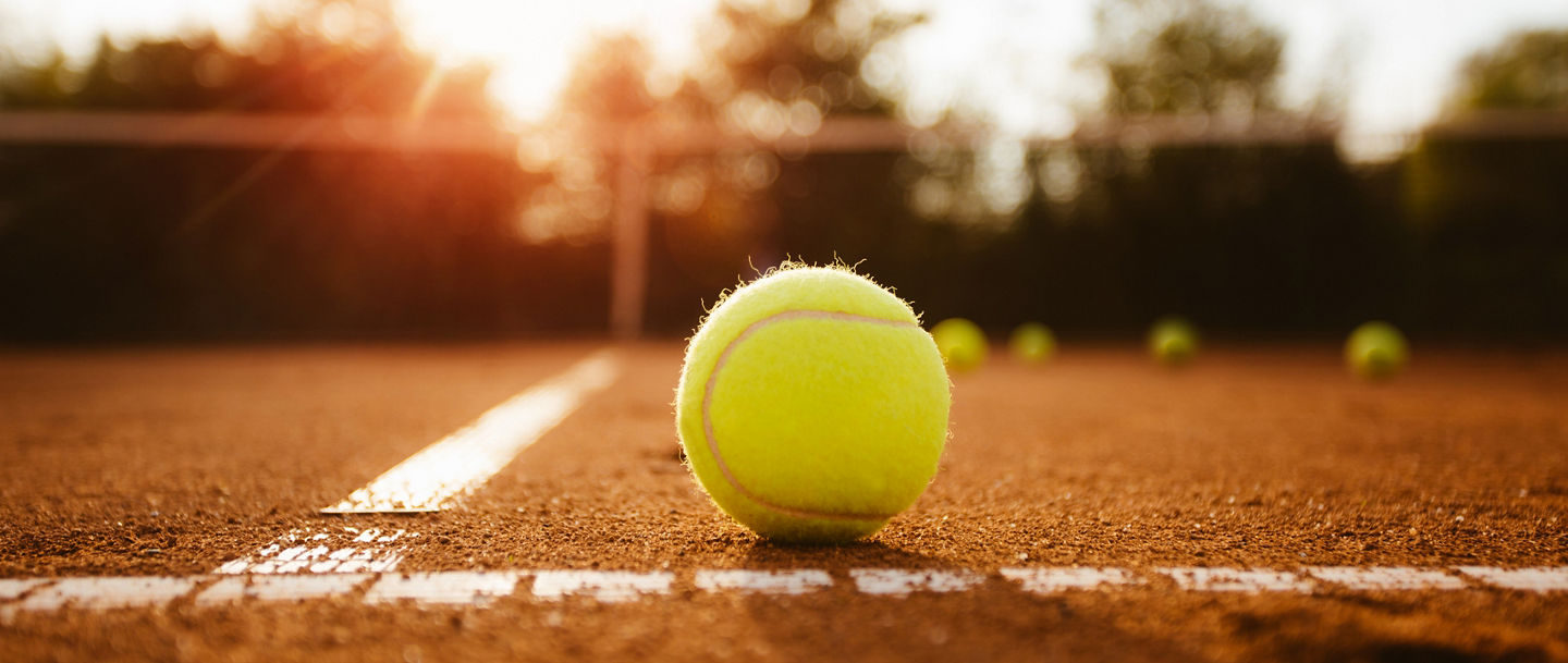Tennisball auf der Grundlinie eines Sandplatzes