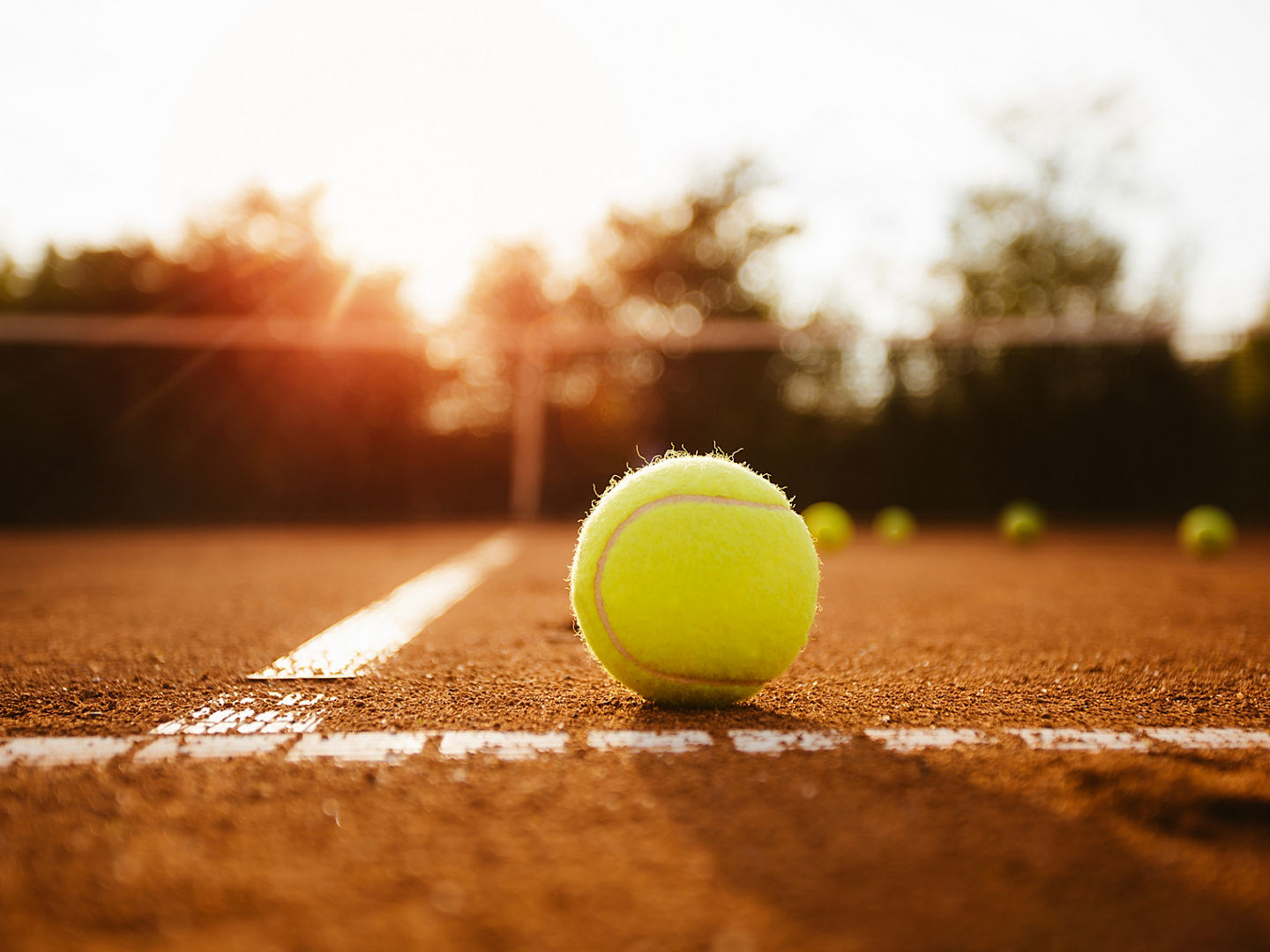 Tennisball auf der Grundlinie eines Sandplatzes