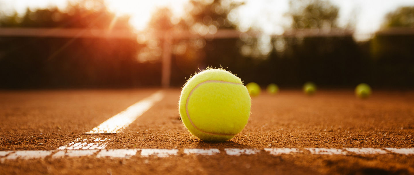 Tennisball auf der Grundlinie eines Sandplatzes