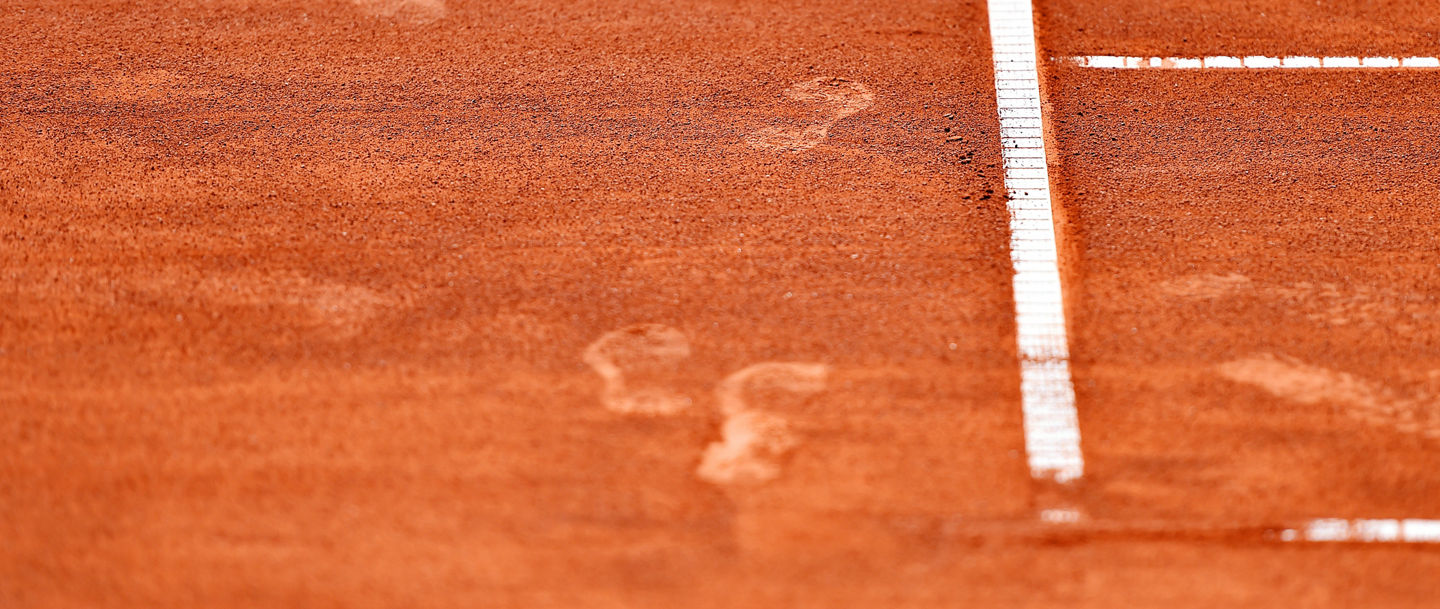 Detail with sport shoe footprints on a tennis clay court