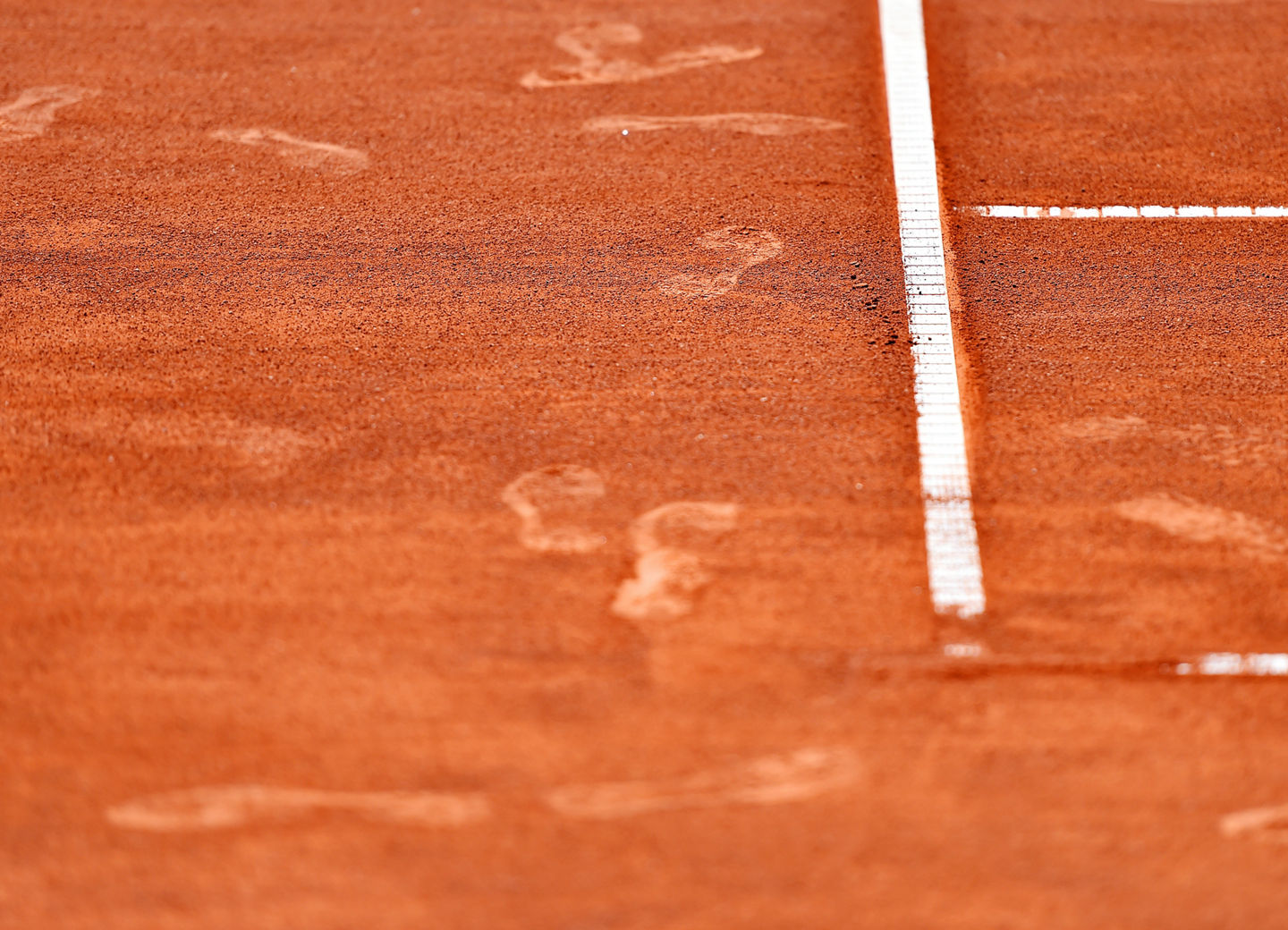 Detail with sport shoe footprints on a tennis clay court