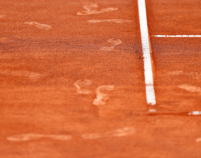 Detail with sport shoe footprints on a tennis clay court