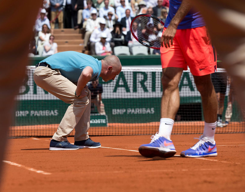 French Open 2015 , Stuhlschiedsrichter Pascal Maria geht in die Knie und pruefed den Ballabdruck auf der Linie,fotografiert durch die Beine des Linienrichters, Tennis - French Open 2015 - Grand Slam ITF / ATP Tennis Herren / WTA Tennis Damen - Roland Garros - Paris - - France - 27 May 2015. Juergen Hasenkopf