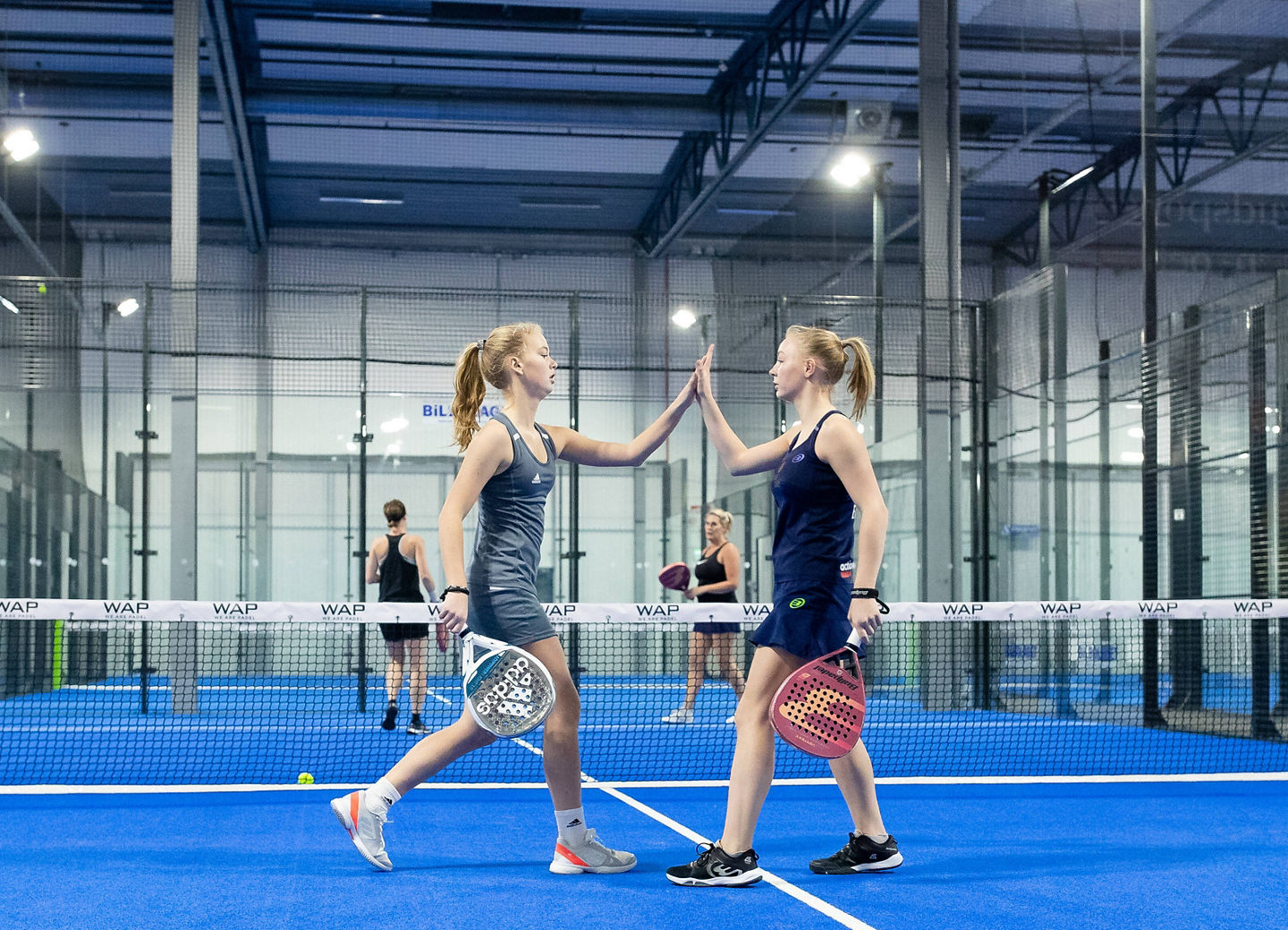 Zwei Padel-Spielerinnen klatschen sich auf dem Court ab