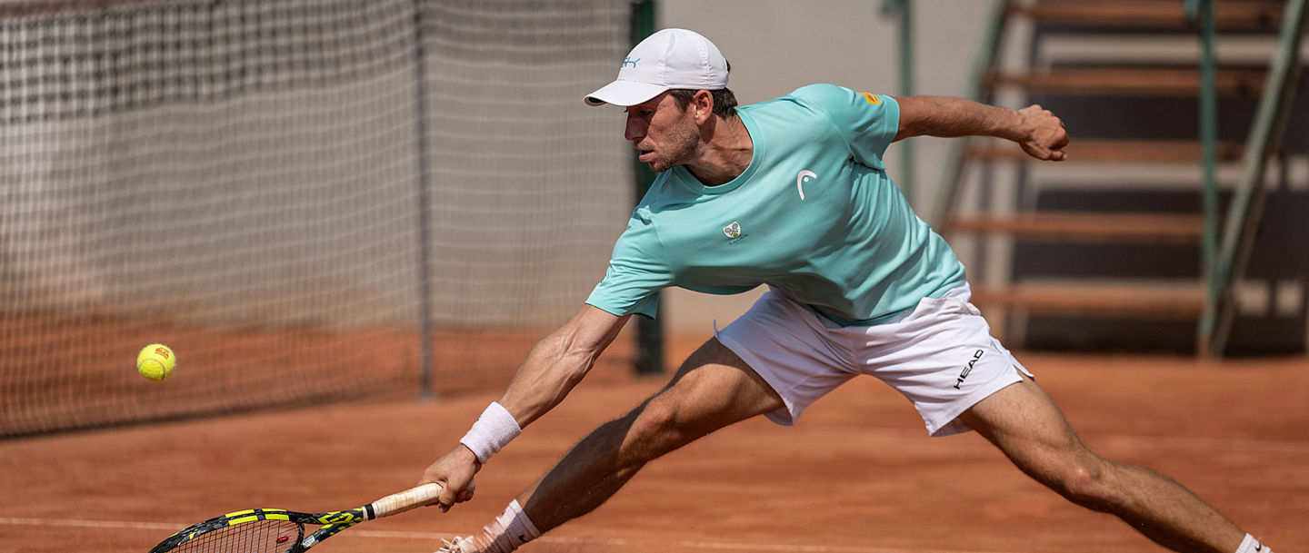 Luca Wiedenmann (TC Augsburg) mit weitem Ausfallschritt am Netz